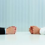 Two businessmen having a discussion. Closeup image of their hands on the table