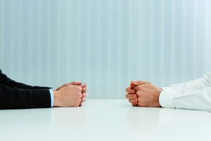 Two businessmen having a discussion. Closeup image of their hands on the table